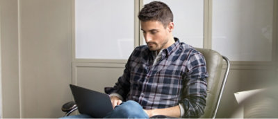 Person using laptop on chair