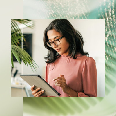 A girl wearing specs and looking at the tablet