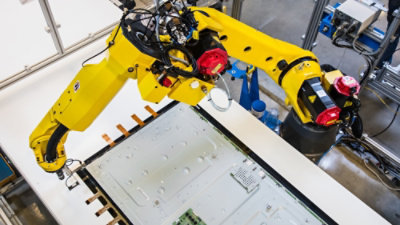 This image shows an industrial robotic arm working in an automated manufacturing environment.