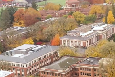 Aerial view of campus buildings surrounded by colorful autumn trees.