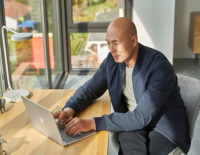 A person sitting on a chair working on his laptop