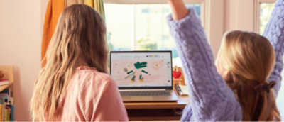 コンピューターの前で手を挙げている女性