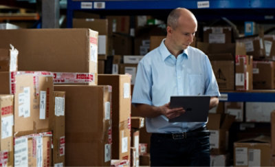 一个人在仓库里拿着一台平板电脑