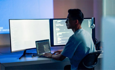 一个人坐在电脑桌旁