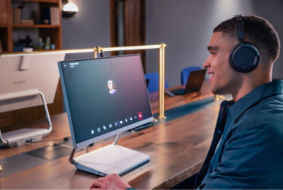 Una persona che indossa cuffie e guarda il monitor di un computer