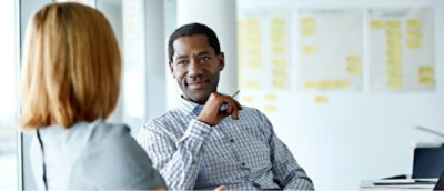 A man sitting in a chair with his hand on his chin.