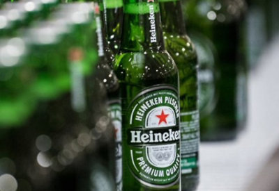 Close-up of Heineken bottles aligned in a row.