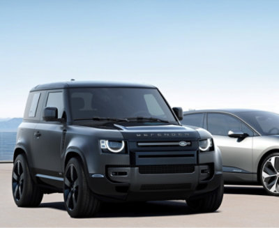A Land Rover Defender parked beside a sleek BMW i8, showcasing the contrast between ruggedness and modern design.