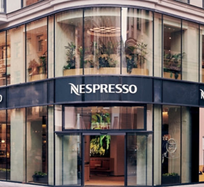 一棟有玻璃窗且顯示文字 NESPRESSO 的建築物。