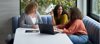 一群人圍坐在有膝上型電腦的桌前。