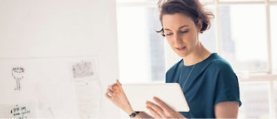 Una mujer con una camiseta azul frente a una ventana