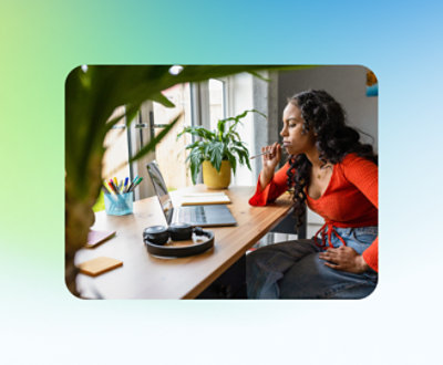 一名坐在辦公桌前穿著紅色上衣的女孩，桌上放有電腦