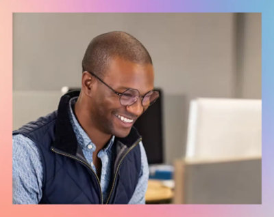 A person smiling at a computer.