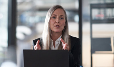  A woman making hand gestures while being on a video call on her laptop