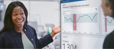 A person presenting a graph on a screen