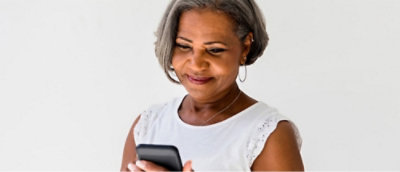 A person smiling while holding a phone