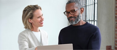 A person and another person looking at a computer
