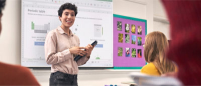 A person holding a tablet in front of a whiteboard.