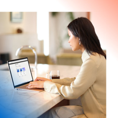 Een vrouw die aan een toonbank zit en een laptop gebruikt.