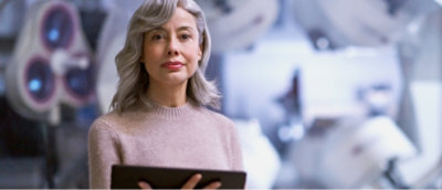 Een vrouw met grijs haar die een tablet vasthoudt.