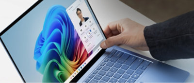 De hand van een persoon die een laptop aanraakt.