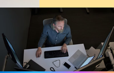 An overhead view of a man working at a desk.