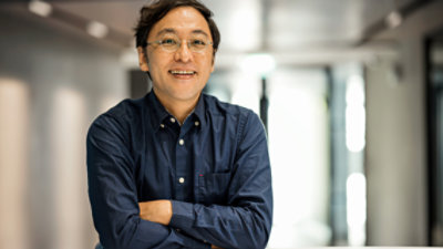 En mand med briller og en blå skjorte.