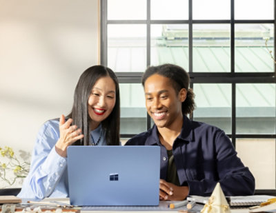 A man and woman looking at a laptop.