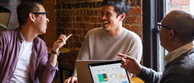 A man smiling at a laptop.