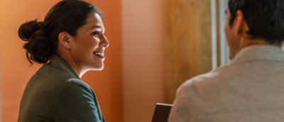 A woman smiling and looking at another woman.
