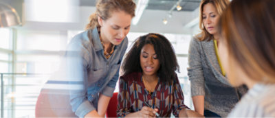 A group of women looking at a piece of paper.