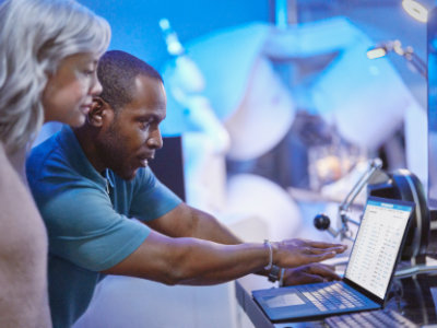 En person og en anden person ser på en computer