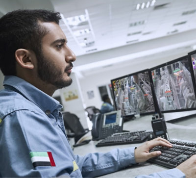 A person sitting at a desk with multiple monitors
