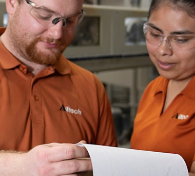 一位男士和一位女士正在检查一张带“Alltech”标记的纸。