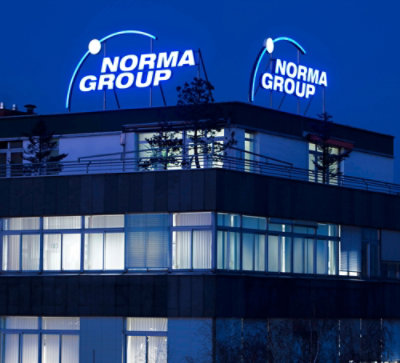 一座建筑物，带有蓝色标志“NORMA GROUP”。