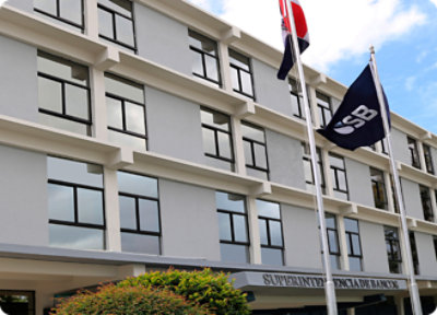 A four-story office building with "Superintendencia de Bancos" sign, multiple windows