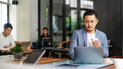 A man working in a lap holding a cup in hand