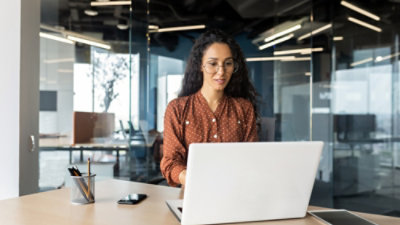 A women working with white colour laptop in a office room