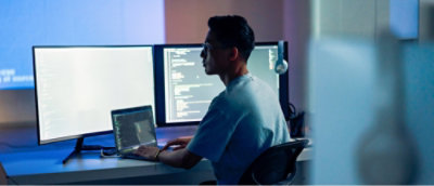 A person sitting at a desk and working on laptop