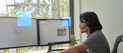 A man wearing headphones and looking at a computer screen.