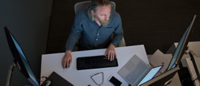 A man sitting at a desk with a keyboard.
