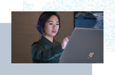 Person standing and interacting with a large touchscreen device in a modern workspace.