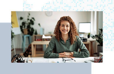 Person seated at a desk, working at a computer in a home office setting.