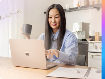 Женщина с ноутбуком держит кружку с кофе и улыбается