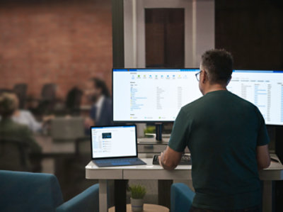 A person sitting at a desk with multiple computer