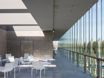 En glasvägg med ett vitt bord och stolar