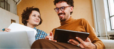 A man and woman looking at a tablet.