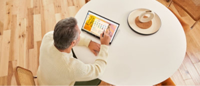 A man sitting at a table using a laptop.