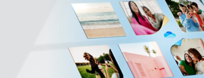 En kvinna i en rosa skjorta står framför en vägg som är täckt av olika fotografier.