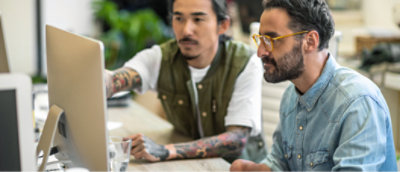 A man with tattoos on his arm pointing at something.